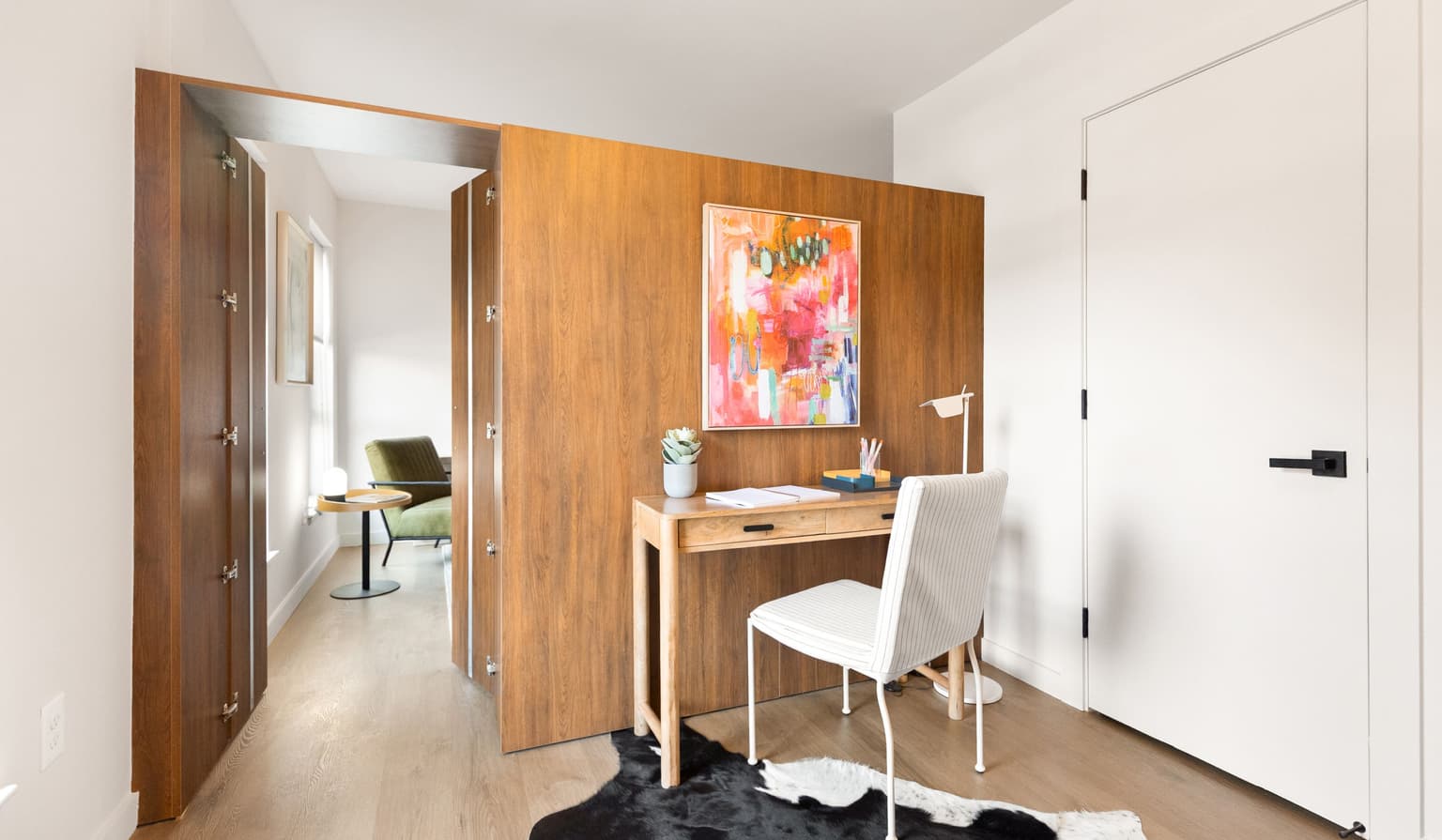 view of den looking out millwork door to living area