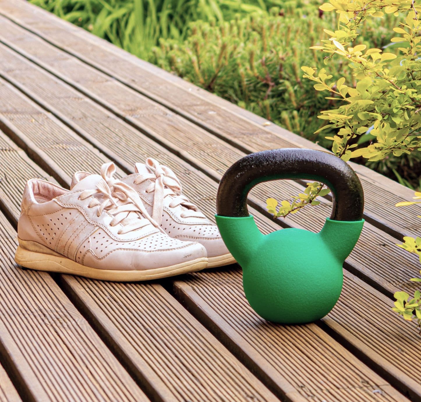 Dumbell and sneakers on fitness deck outside